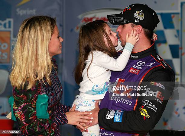 Denny Hamlin, driver of the FedEx Ground Toyota, celebrates with his girlfriend Jordan Fish and their daughter Taylor in Victory Lane after winning...