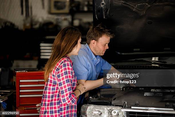 der kunde bespricht reparaturen mit dem automechaniker in der werkstatt. - happy client by broken car stock-fotos und bilder