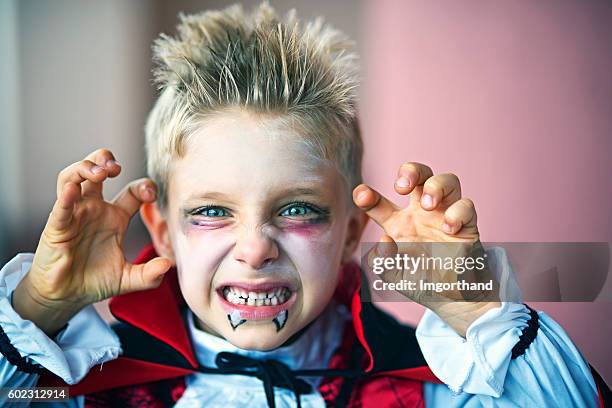 porträt eines kleinen jungen verkleidet als halloween-vampir - historische kleidung stock-fotos und bilder