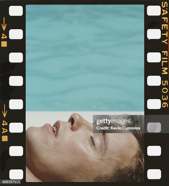 Singer and guitarist Bernard Sumner of English rock group New Order, relaxing by a swimming pool, Washington DC, 9th July 1983.