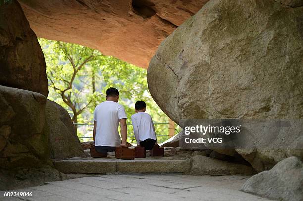 Legless motivational speaker Chen Zhou and legless teenager Gao Zhiyu climb the Mount Lao on September 10, 2016 in Qingdao, Shandong Province of...