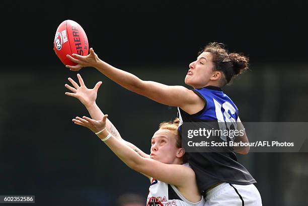 Alicia Eva of Melbourne Uni is congratulated by Ellie Blackburn and Catherine O'Bryan after kicking a goal during the Women's VFL Preliminary Final...