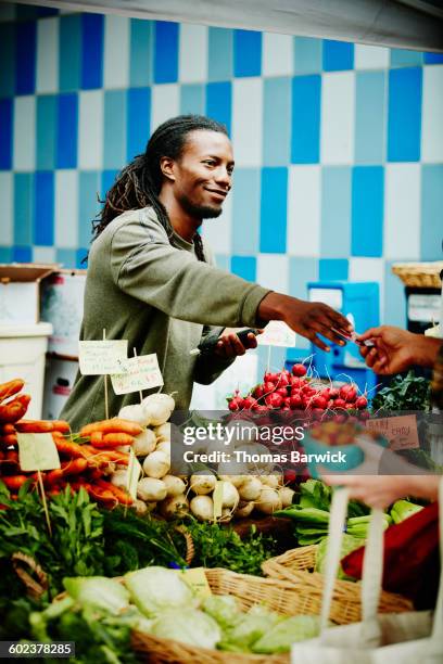 smiling farmer taking customer credit card - market vendor fotografías e imágenes de stock