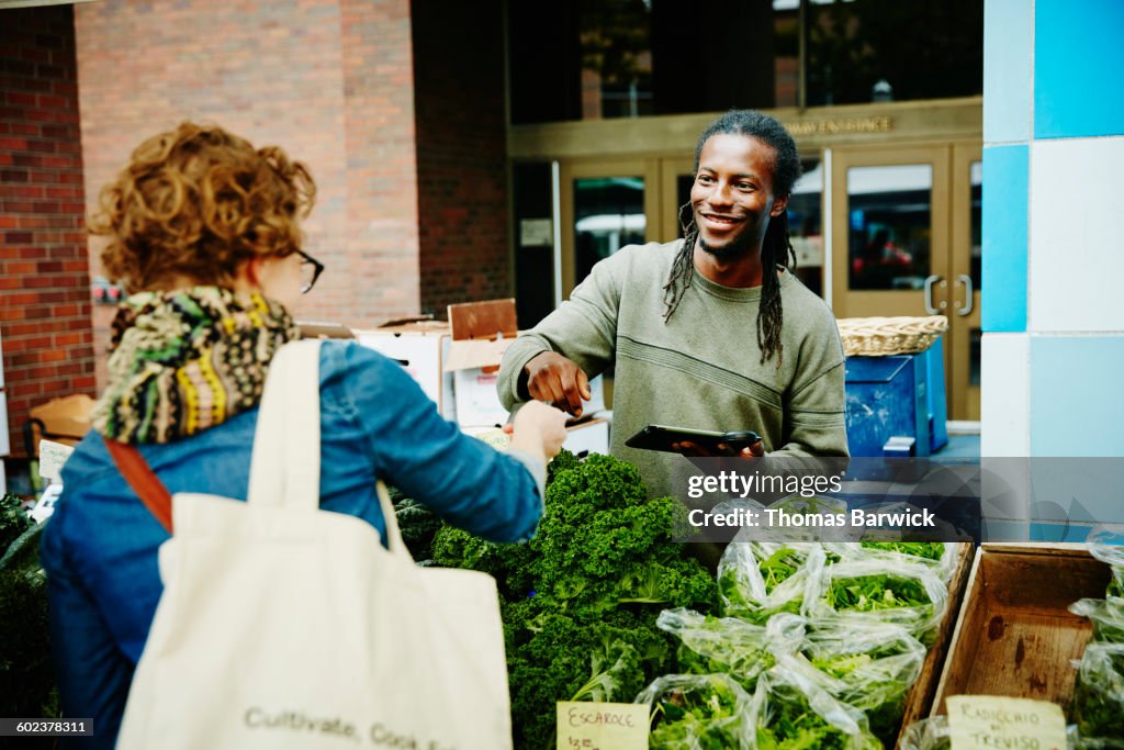 Farmer taking credit card from customer