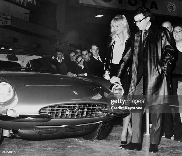 British comic actor Peter Sellers and his wife, Swedish actress Britt Ekland, inspecting a Ferrari 500 Superfast coupe, which Sellers has just bought...