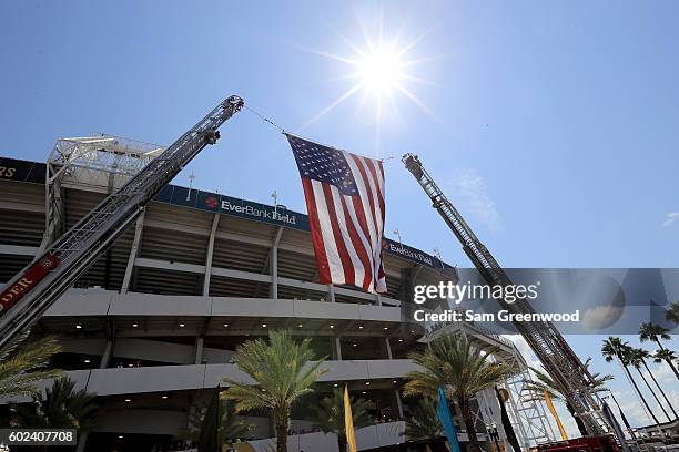 Fire trucks display an American flag from their ladders prior to the game between the Jacksonville Jaguars and Green Bay Packers at EverBank Field on...