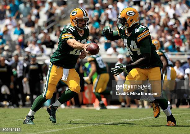 Aaron Rodgers of the Green Bay Packers hands off to James Starks during the game against the Jacksonville Jaguars at EverBank Field on September 11,...