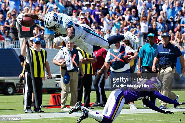 DeMarco Murray of the Tennessee Titans dives over Terence Newman of the Minnesota Vikings into the end zone for a touchdown during the first half of...