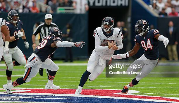 Brock Osweiler of the Houston Texans scrambles out of the pocket to avoid Leonard Floyd of the Chicago Bears and Danny Trevathan at NRG Stadium on...
