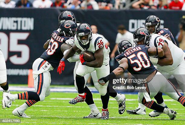 Lamar Miller of the Houston Texans rushes between Jerrell Freeman of the Chicago Bears and Danny Trevathan in the first quarter at NRG Stadium on...