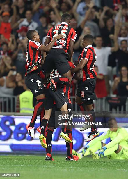 Nice's Italian forward Mario Balotelli is congratulated by teammates after scoring a goal during the French L1 football match OGC Nice vs Olympique...