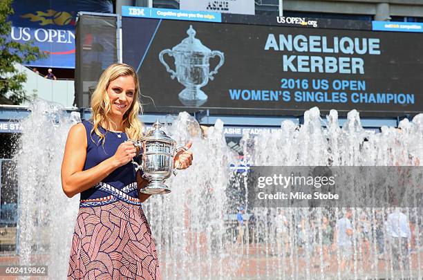 The 2016 US Open Women's Singles champion Angelique Kerber of Germany poses with her trophy by the fountains in the south plaza on Day Fourteen of...