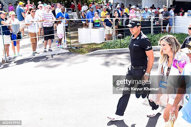 Jason Day of Australia leaves the clubhouse with his wife Ellie after withdrawing in the final round of the BMW Championship at Crooked Stick Golf...