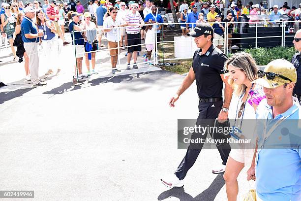 Jason Day of Australia leaves the clubhouse with his wife Ellie after withdrawing in the final round of the BMW Championship at Crooked Stick Golf...