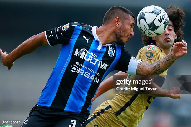 Matias Britos of Pumas fights and Miguel Martinez of Queretaro jump for a header during the 8th round match between Pumas UNAM and Queretaro as part...