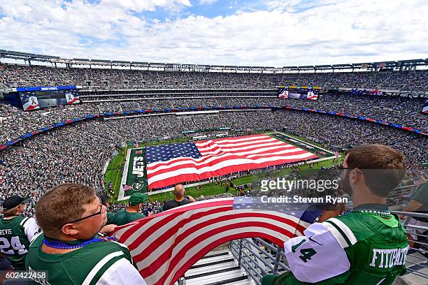Fans hold an American flag during the National Anthem prior to the game between the New York Jets and the Cincinnati Bengals at MetLife Stadium on...
