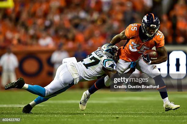 Running back Kapri Bibbs of the Denver Broncos his hit by defensive back Robert McClain of the Carolina Panthers in the third quarter of a game at...