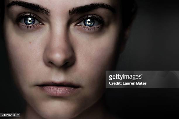 woman in darkness - bold eyebrows stock-fotos und bilder