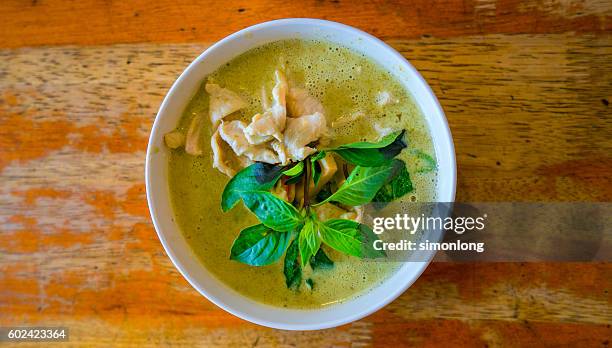 thai green curry served in bowl on table - curry soup stock-fotos und bilder