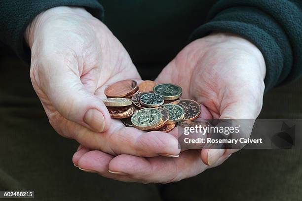 hands holding small change in british coins - british coin stock pictures, royalty-free photos & images