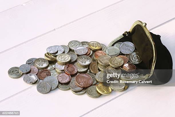 numerous british coins spill from black purse - pièce de monnaie britannique photos et images de collection