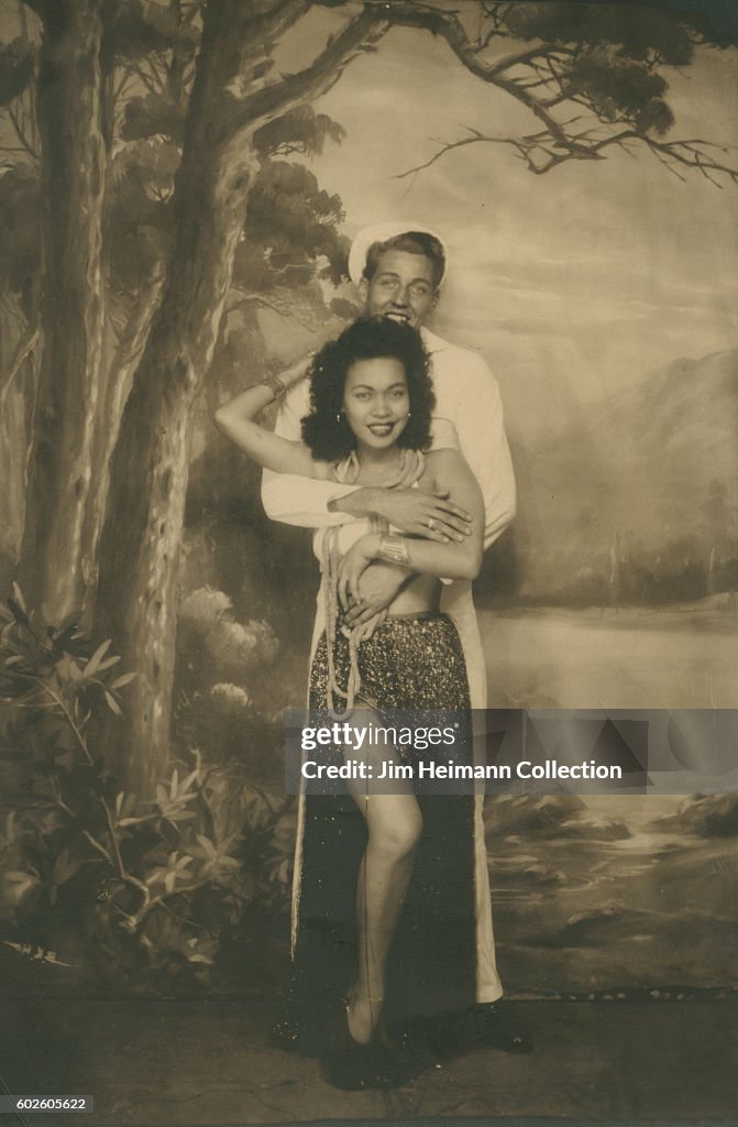 Sailor poses with woman.