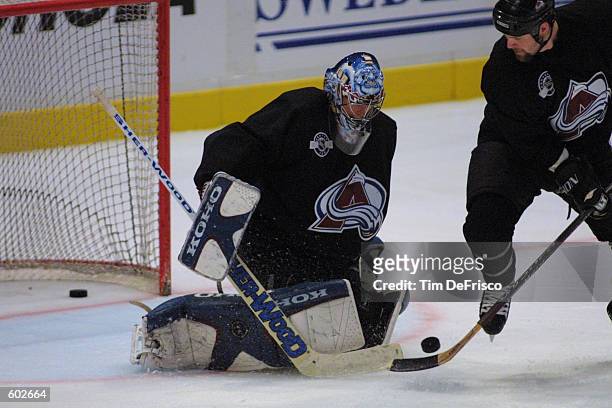 Right winger Scott Parker tries to get the puck past goaltender David Aebischer of the Colorado Avalanche at a training camp session during the 2001...