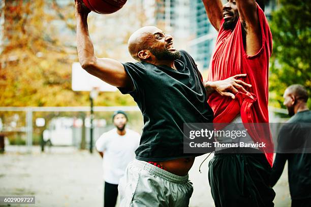 basketball player attempting to dunk on defender - anfallsspel bildbanksfoton och bilder