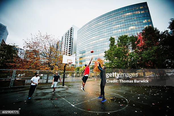 basketball player taking shot during pick up game - city life authentic stock pictures, royalty-free photos & images