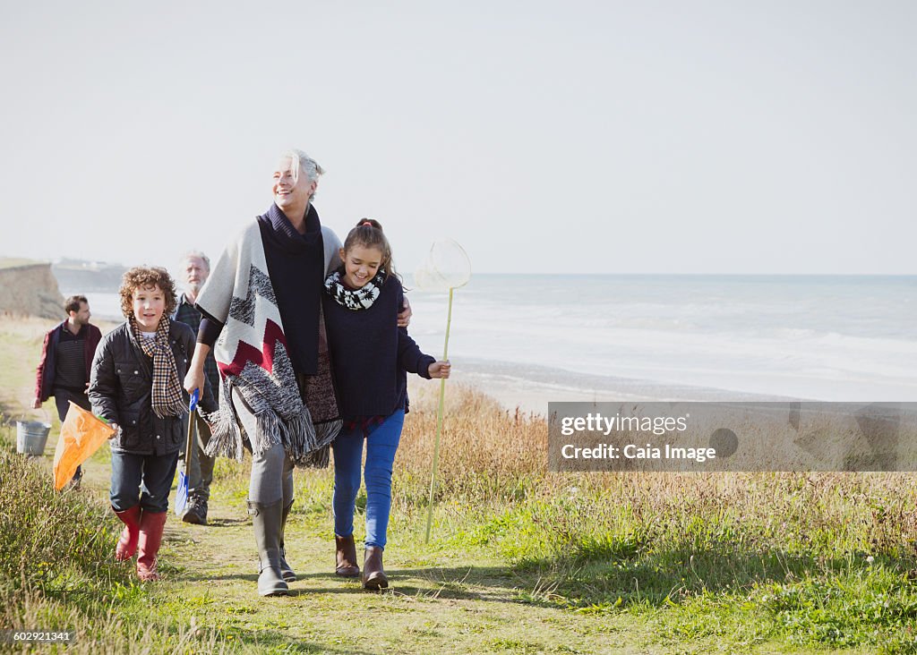 Multi-generation family walking on grassy beach path