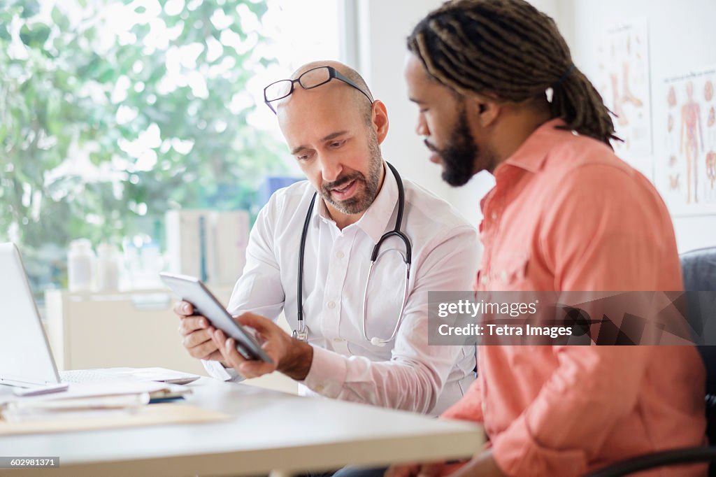 Doctor giving consultation to patient using digital tablet