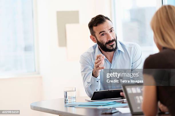 man and woman talking in office - arab business woman stockfoto's en -beelden