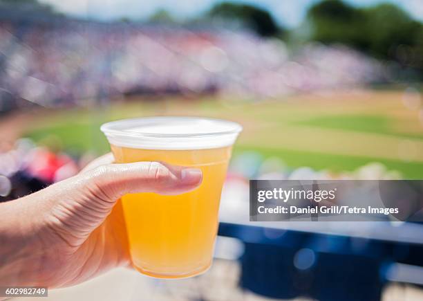 usa, maine, portland, close-up of hand holding beer at stadium - beer close up stock-fotos und bilder