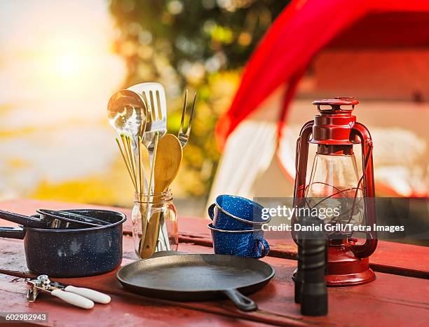 usa, maine, acadia national park, oil lamp, binoculars and cooking utensils on picnic table - camping equipment stock pictures, royalty-free photos & images
