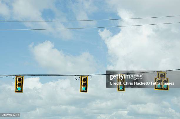 usa, south carolina, road signals on cable against cloudy sky - ampel stock-fotos und bilder