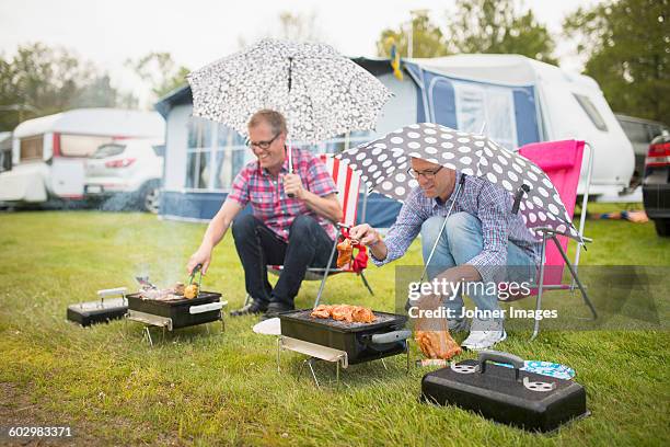 men barbecuing in rain - rainy day stockfoto's en -beelden