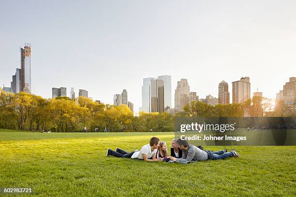 friends relaxing together in park - couple central park stockfoto's en -beelden