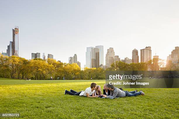 friends relaxing together in park - new york city park stock pictures, royalty-free photos & images