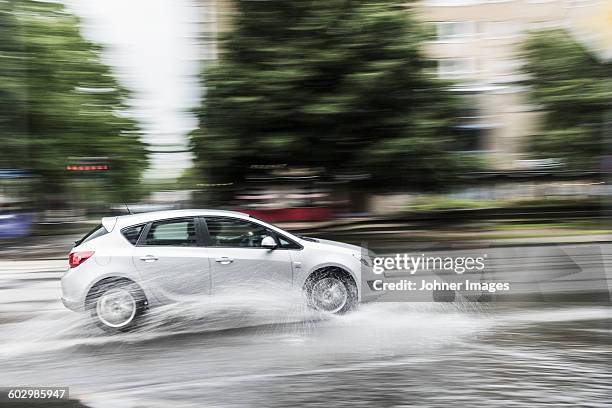 car splashing water on road - rain road stock pictures, royalty-free photos & images