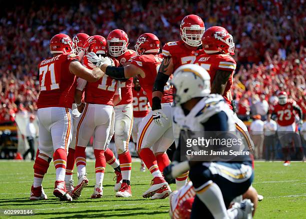 Quarterback Alex Smith of the Kansas City Chiefs is congratulated by teammates after scoring a touchdown to win the game against the San Diego...