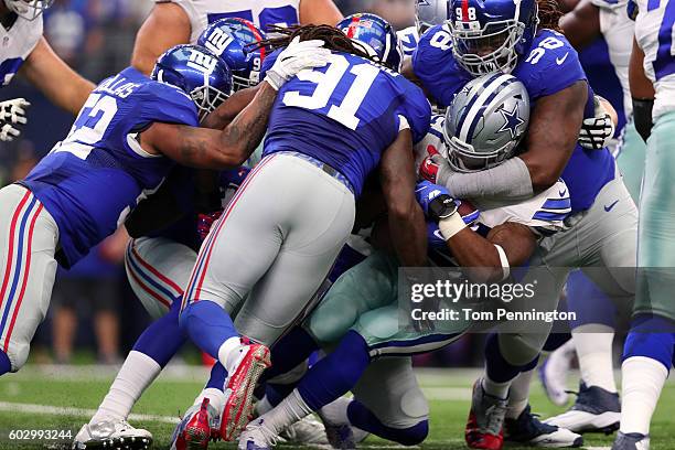 Ezekiel Elliott of the Dallas Cowboys is tackled by Damon Harrison and Kelvin Sheppard of the New York Giants during the first quarter at AT&T...