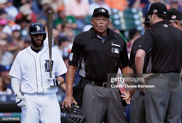 Home plate umpire Kerwin Danley flexes his left hand after getting hit by a ball during the sixth inning as J.D. Martinez of the Detroit Tigers waits...