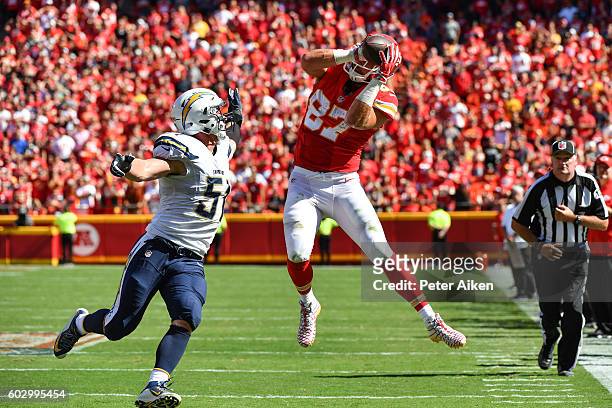 Tight end Travis Kelce of the Kansas City Chiefs makes an amazing leaping catch over the outstretched arm of outside linebacker Kyle Emanuel of the...