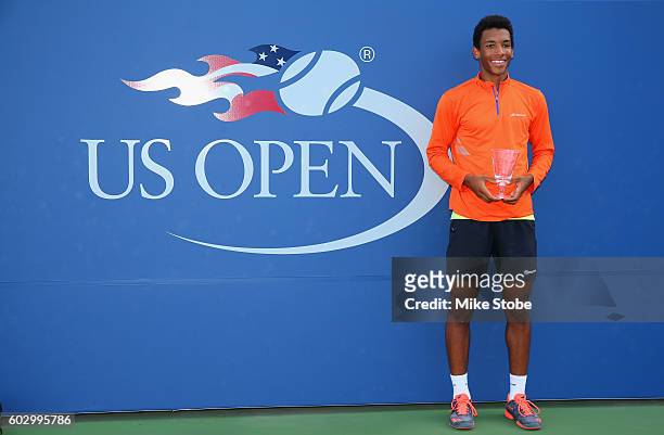 Felix Auger-Aliassime of Canada celebrates with the trophy after defeating Miomir Kecmanovic of Serbia in their Junior Boys' Doubles match on Day...