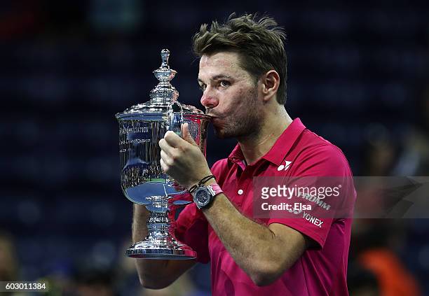 Stan Wawrinka of Switzerland celebrates with the trophy after defeating Novak Djokovic of Serbia with a score of 6-7, 6-4, 7-5, 6-3 during their...
