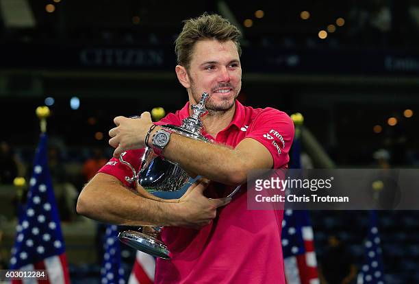 Stan Wawrinka of Switzerland celebrates with the trophy after winning 6-7, 6-4, 7-5, 6-3 against Novak Djokovic of Serbia during their Men's Singles...