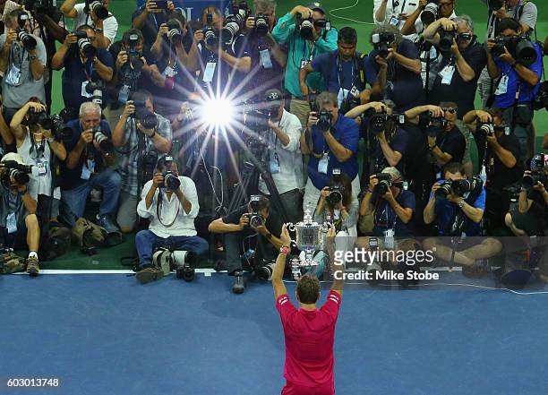 The media photographs Stan Wawrinka of Switzerland celebrating with the trophy after winning 6-7, 6-4, 7-5, 6-3 against Novak Djokovic of Serbia...