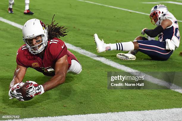 Wide receiver Larry Fitzgerald of the Arizona Cardinals dives in front of cornerback Logan Ryan of the New England Patriots to score a touchdown in...