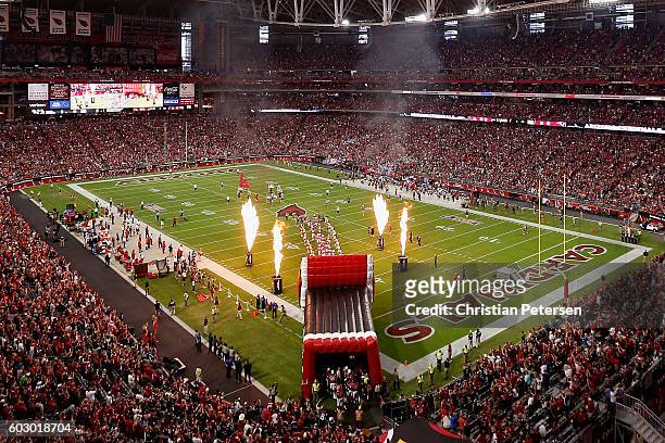The Arizona Cardinals run onto the field for the NFL game against the New England Patriots at the University of Phoenix Stadium on September 11, 2016...