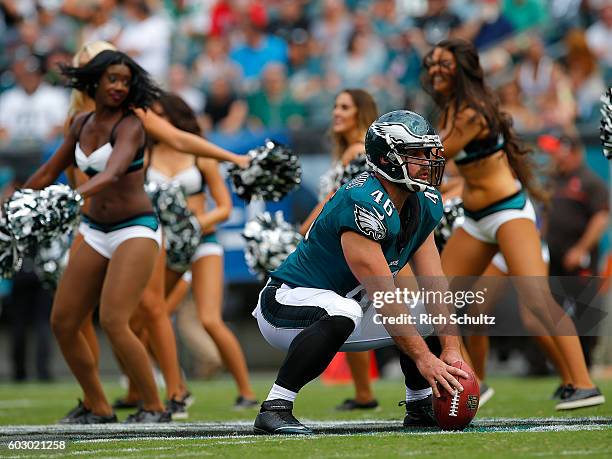 Jon Dorenbos of the Philadelphia Eagles practices his snaps as the team's cheerleaders perform before a game between the Cleveland Browns and Eagles...